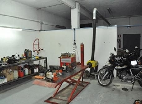 Una motocicleta está parada en un elevador en un garaje.