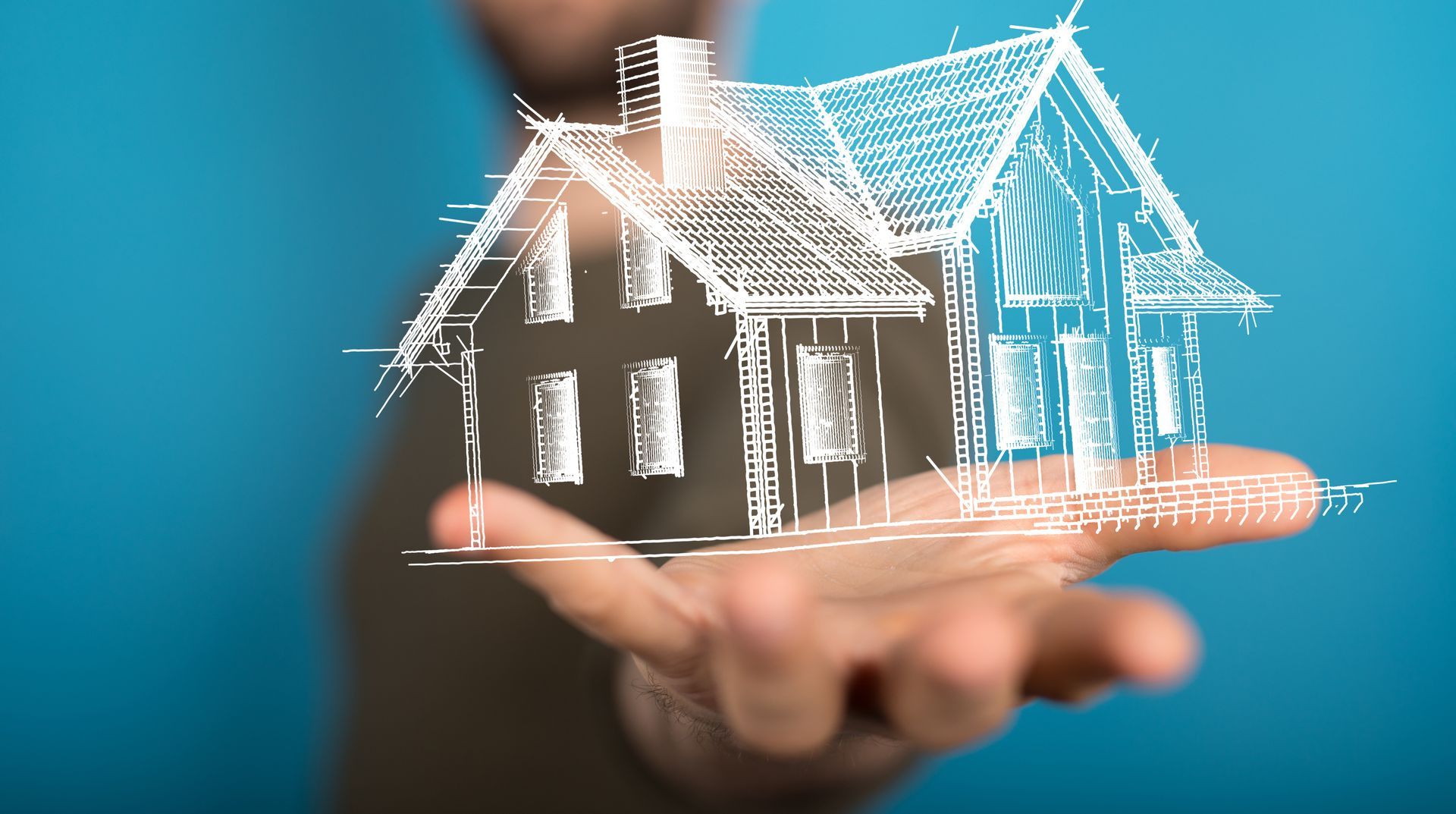 Ein Mann hält eine Zeichnung eines Hauses in seiner Hand.