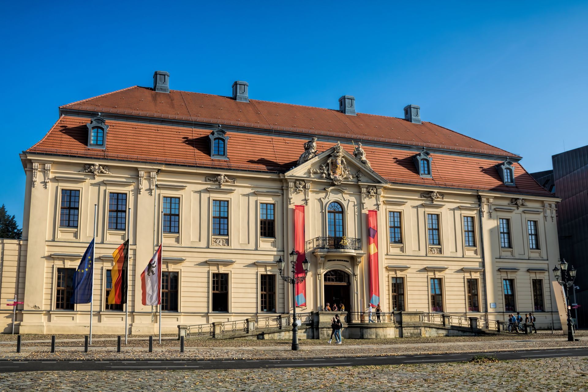 Ein großes weißes Gebäude mit einem roten Ziegeldach