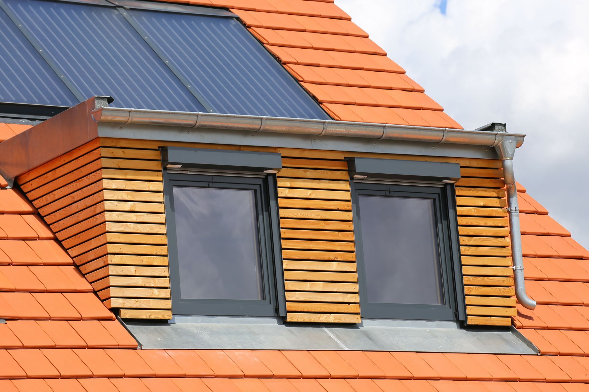Ein Dach mit zwei Fenstern und Sonnenkollektoren darauf