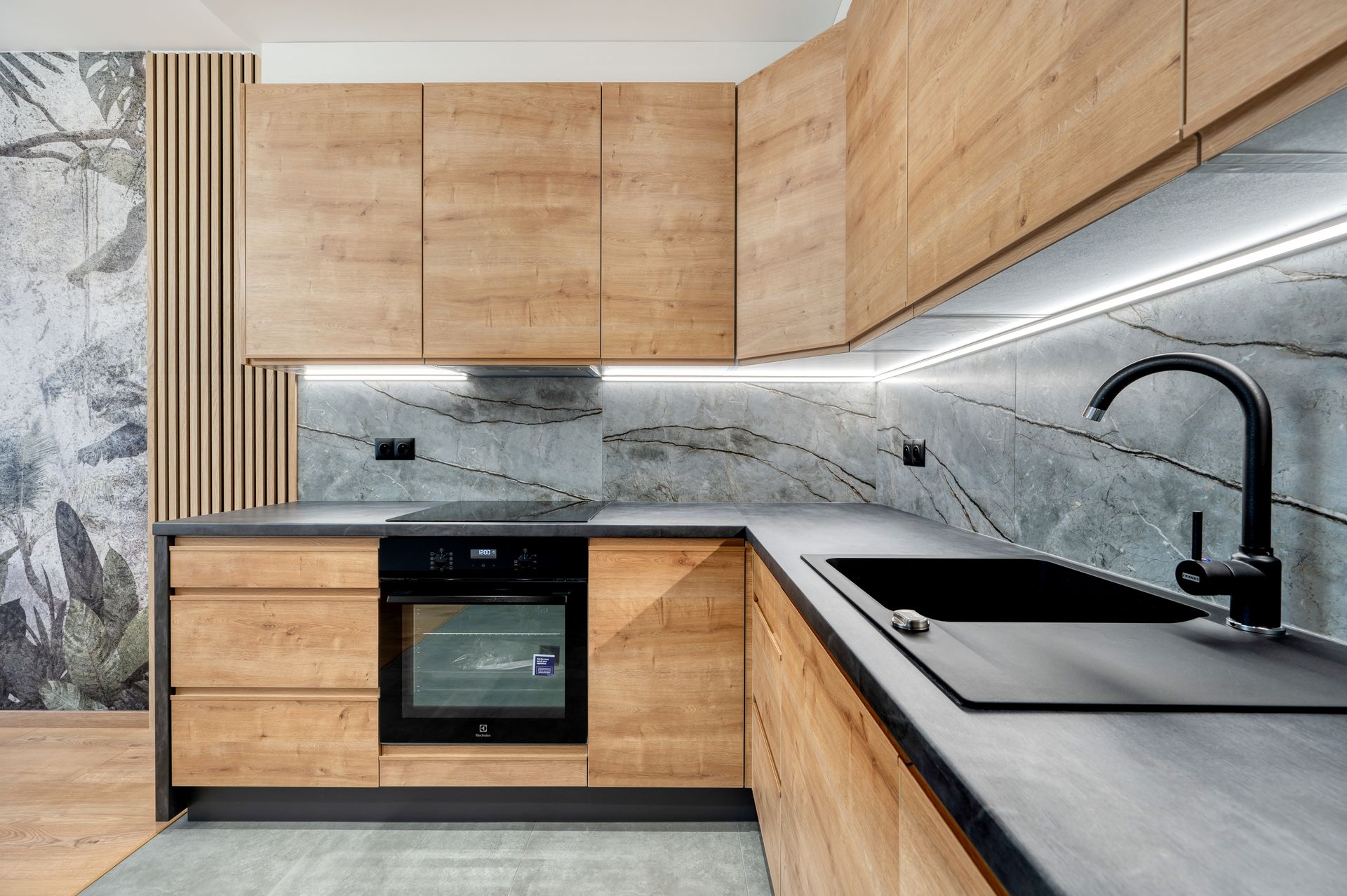 Eine Küche mit Holzschränken und einer schwarzen Spüle.