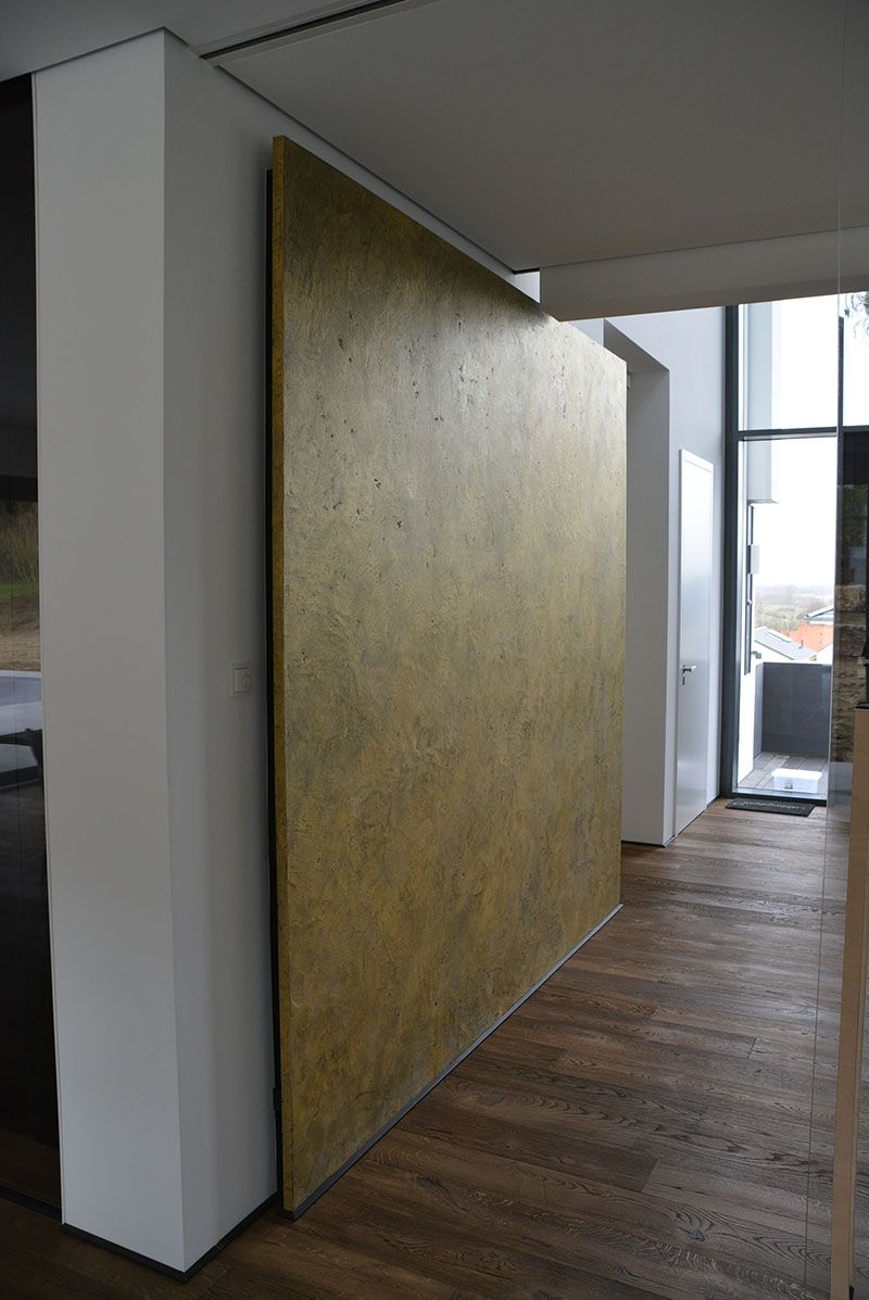 In der Mitte eines Flurs steht eine große goldene Wand.