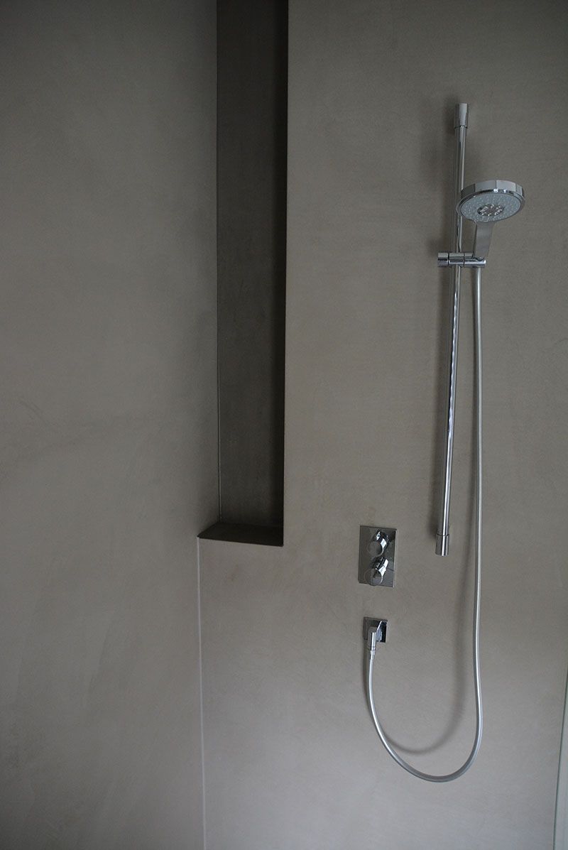 In einem Badezimmer hängt an der Wand ein Duschkopf.