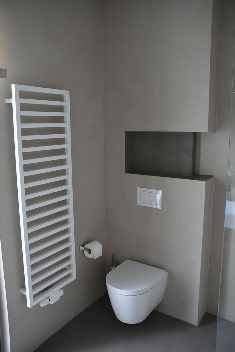 Ein Badezimmer mit Toilette und Handtuchhalter