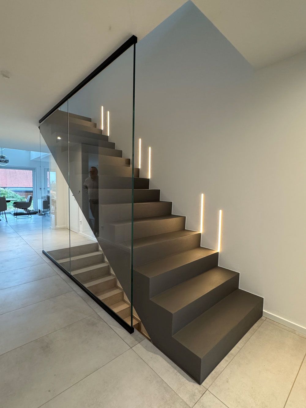 Eine Frau mit einem Handtuch um den Kopf lächelt im Badezimmer.