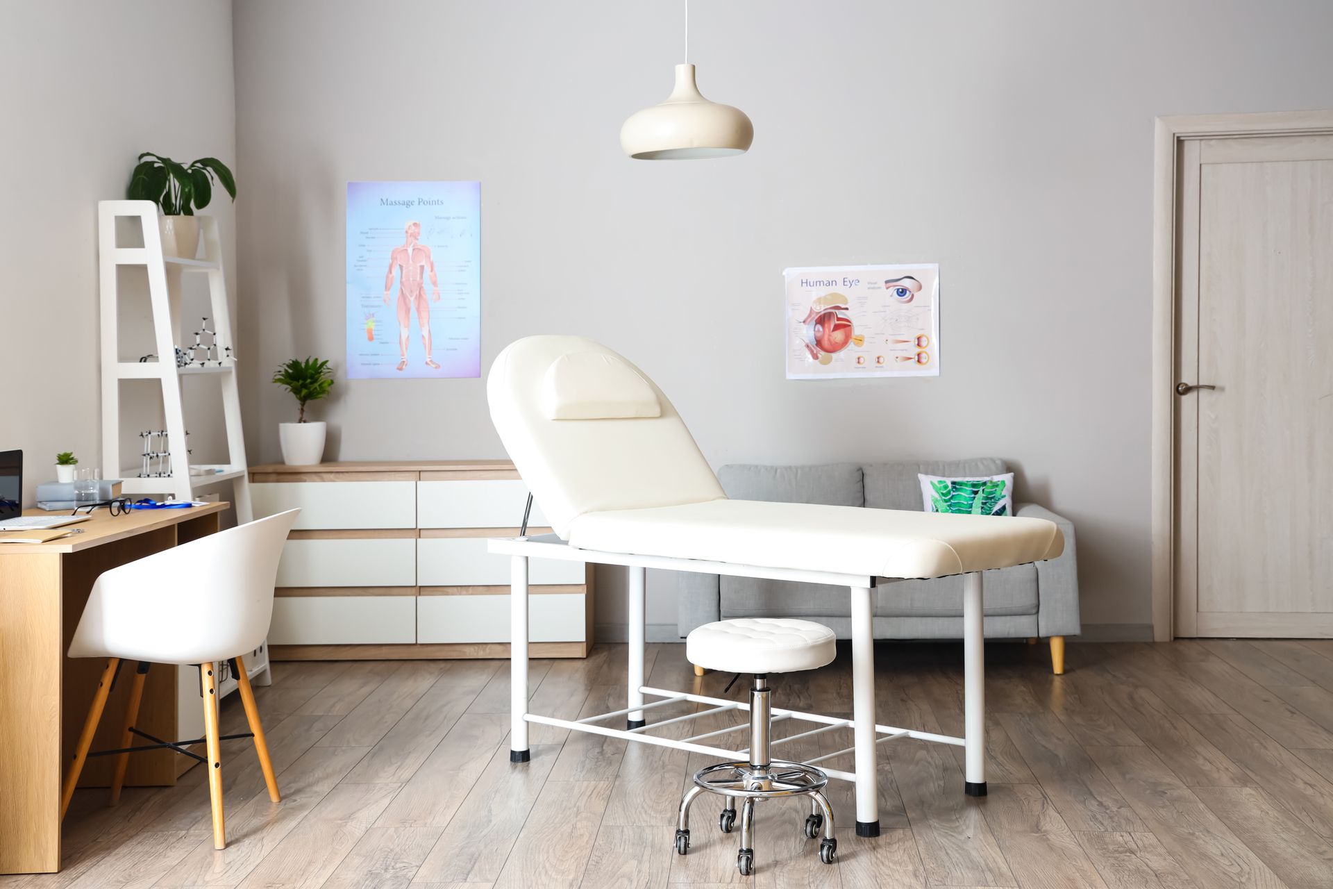 Une salle de soins médicaux ou esthétiques lumineuse et moderne, avec une table d'examen blanche.