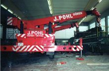 Ein roter Kran steht in einer Garage.