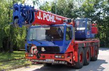 Ein blau-roter Kranwagen steht am Straßenrand.