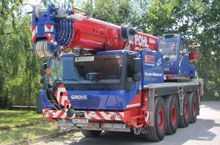 Ein blau-roter Kranwagen steht am Straßenrand.
