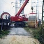 Ein roter Kran steht oben auf einem Feldweg.