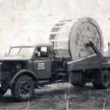 Ein Schwarzweißfoto eines LKWs, der ein großes Objekt zieht.