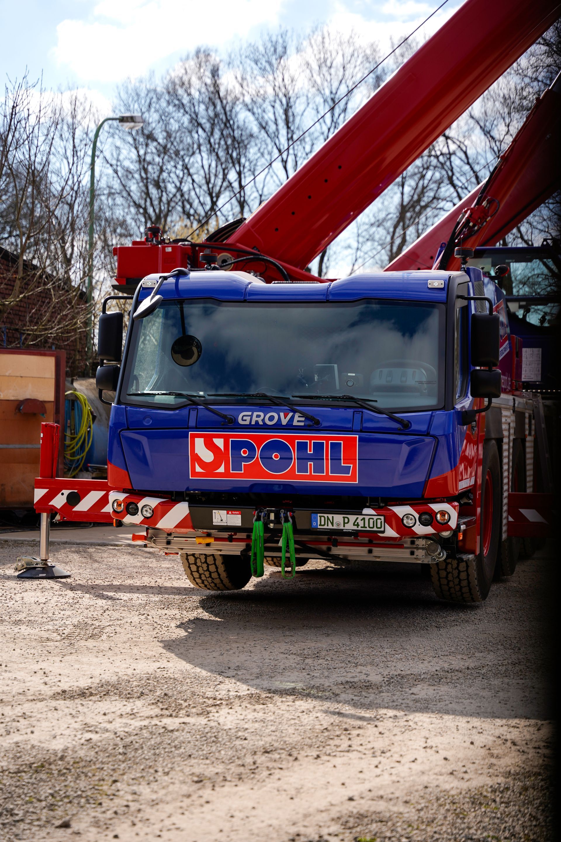Ein LKW mit einem Frachtcontainer auf der Ladefläche steht vor einem Gebäude.