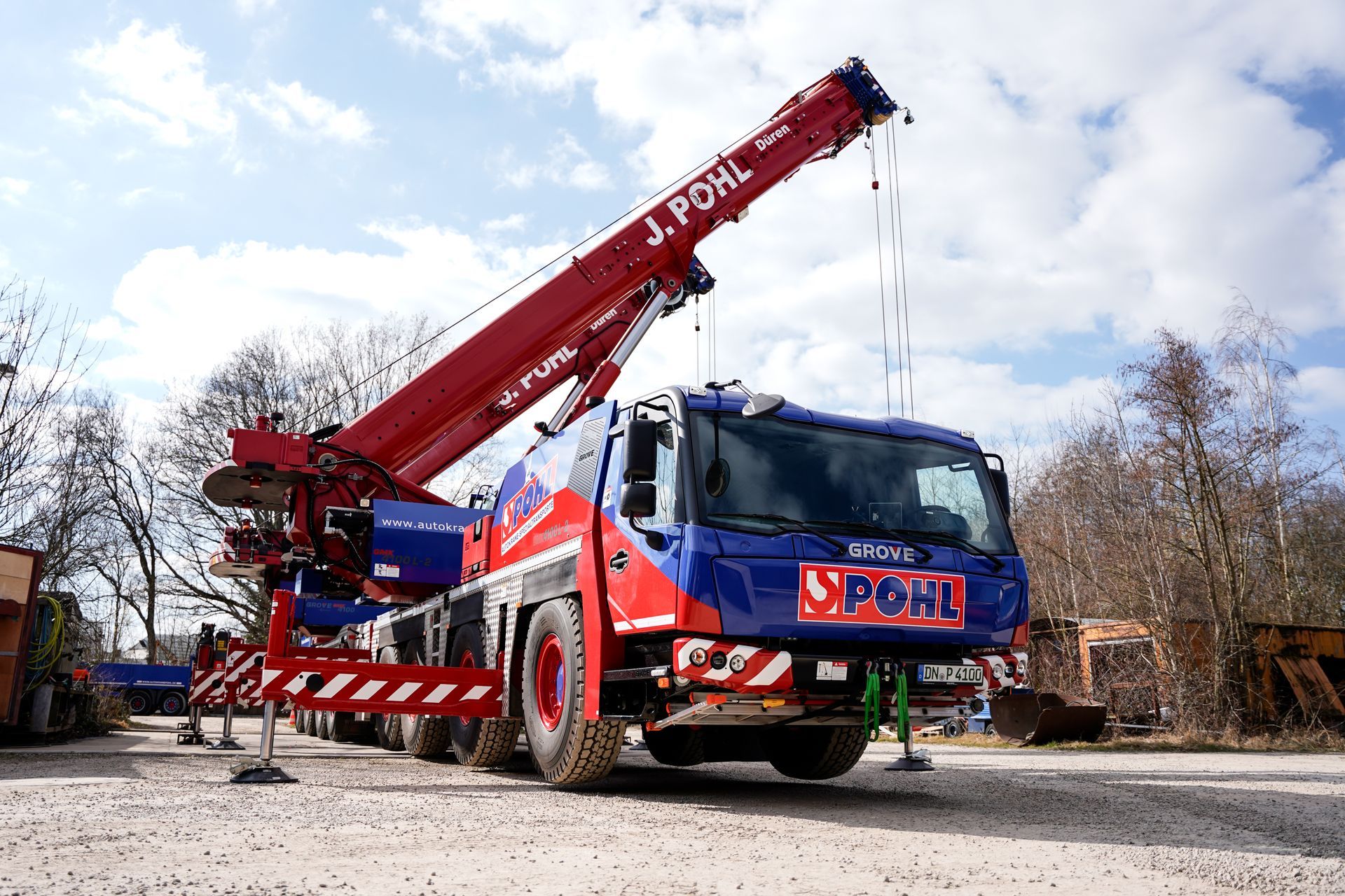 Ein rot-blauer Kran hebt ein großes Objekt