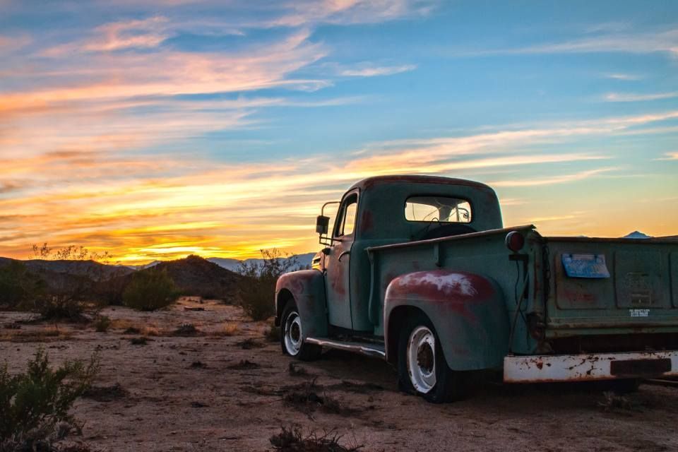 Ein alter Lastwagen parkt bei Sonnenuntergang in der Wüste.