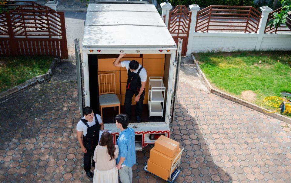 Eine Gruppe von Menschen steht vor einem Transporter mit Paketen