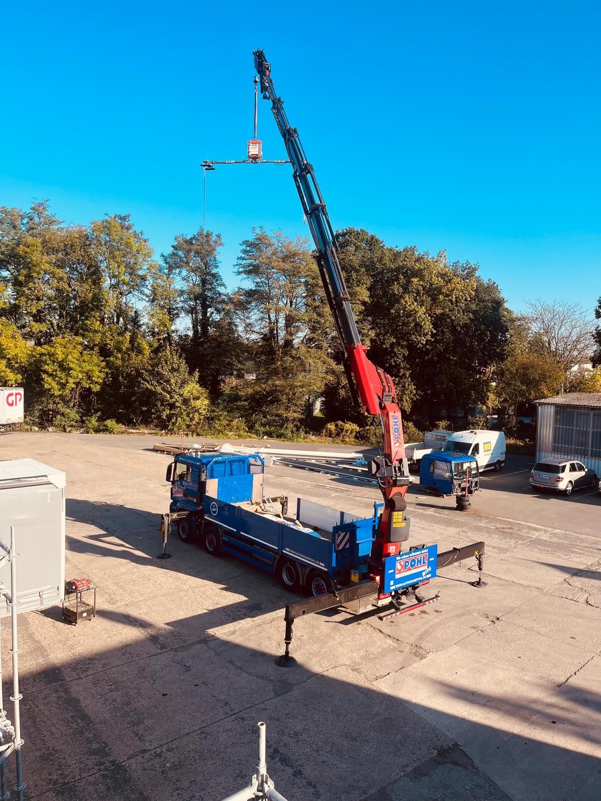 Ein Mann schiebt einen Hubwagen mit Kisten darauf.