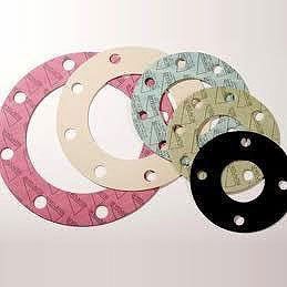 Juntas de varios colores y tamaños, con orificios para pernos, se apilan sobre un fondo blanco.