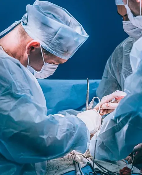 Un grupo de cirujanos está operando a un paciente en un quirófano.