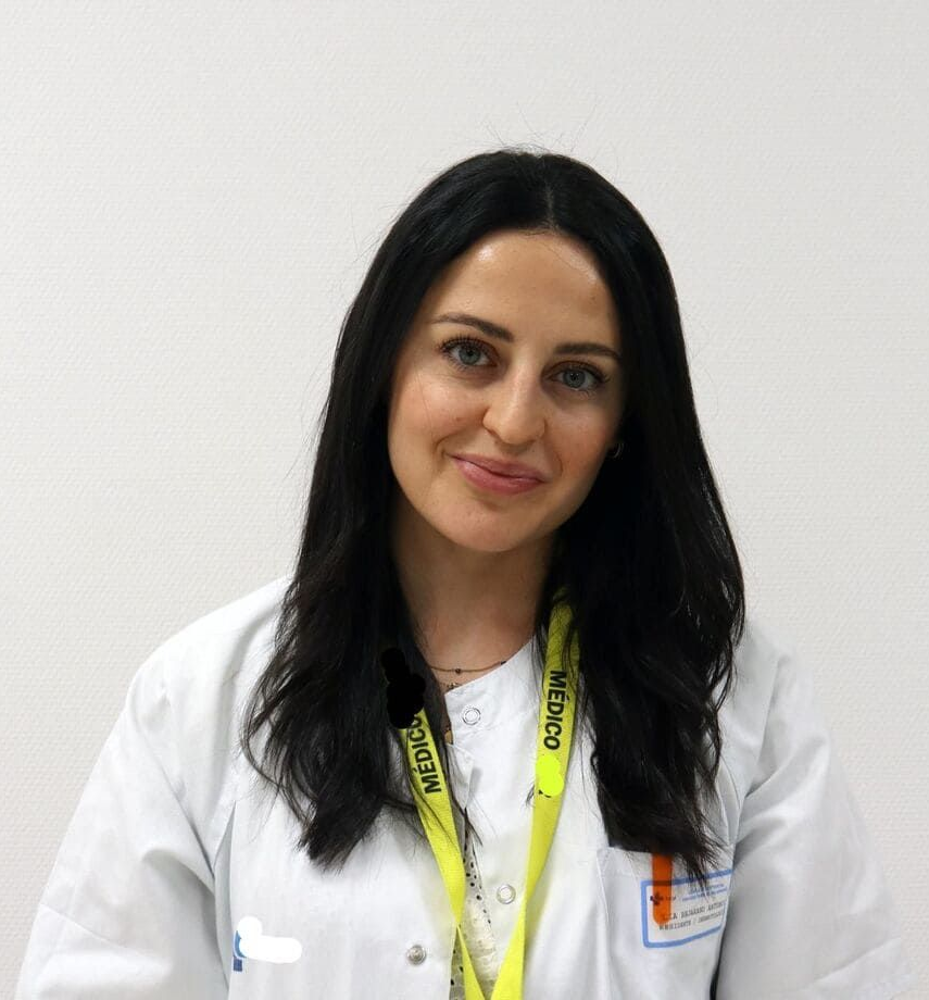 Un hombre con traje y camisa blanca sonríe a la cámara.