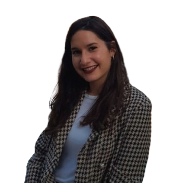Una mujer que lleva una chaqueta a cuadros y una camisa blanca sonríe a la cámara.
