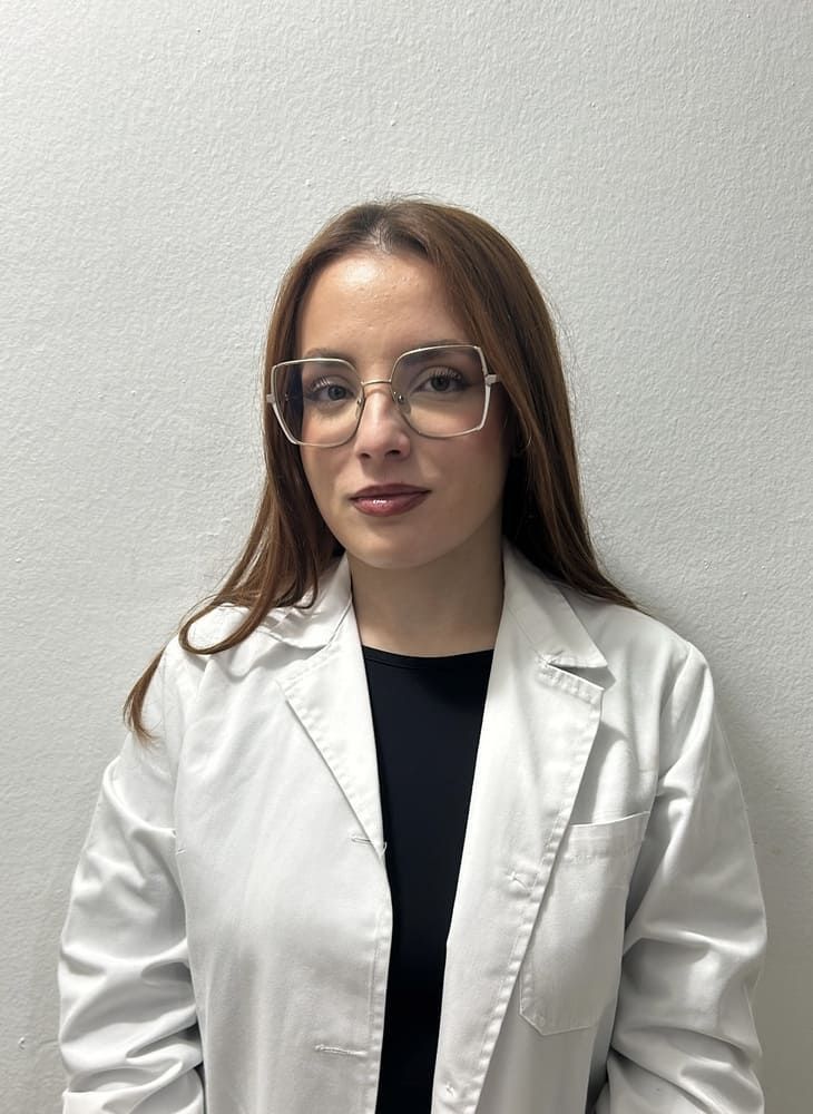 Un hombre con traje y camisa blanca sonríe a la cámara.