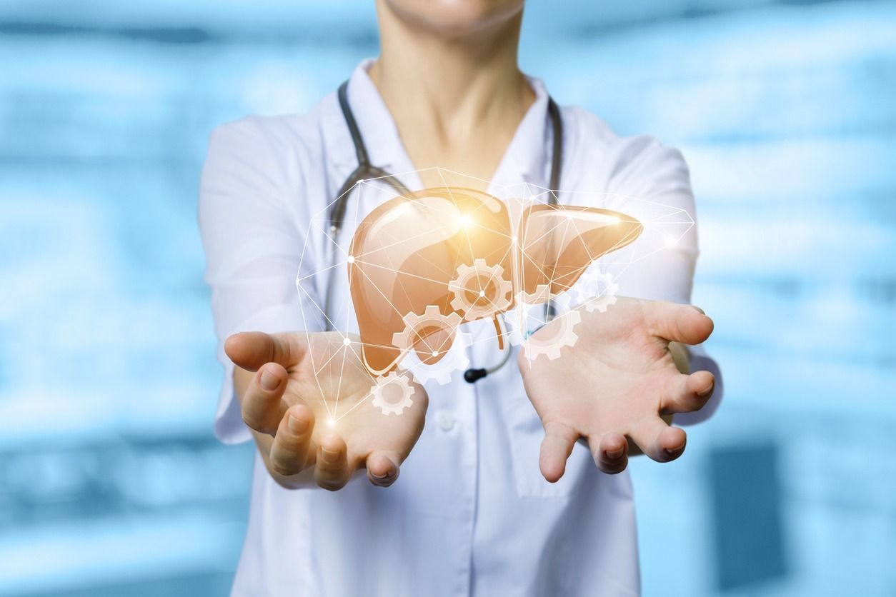 Un médico sostiene en sus manos una imagen de un hígado.