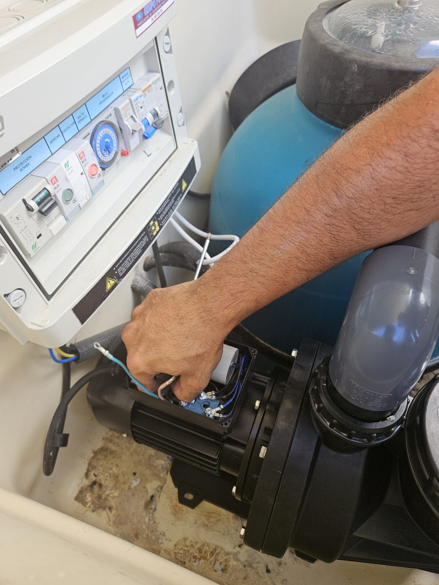 Una persona está trabajando en una bomba de piscina.