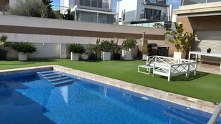 Una gran piscina está en el patio trasero de una casa.