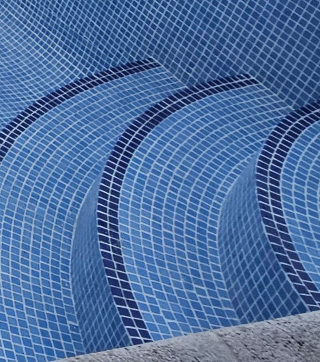 Un primer plano de una piscina con azulejos azules.