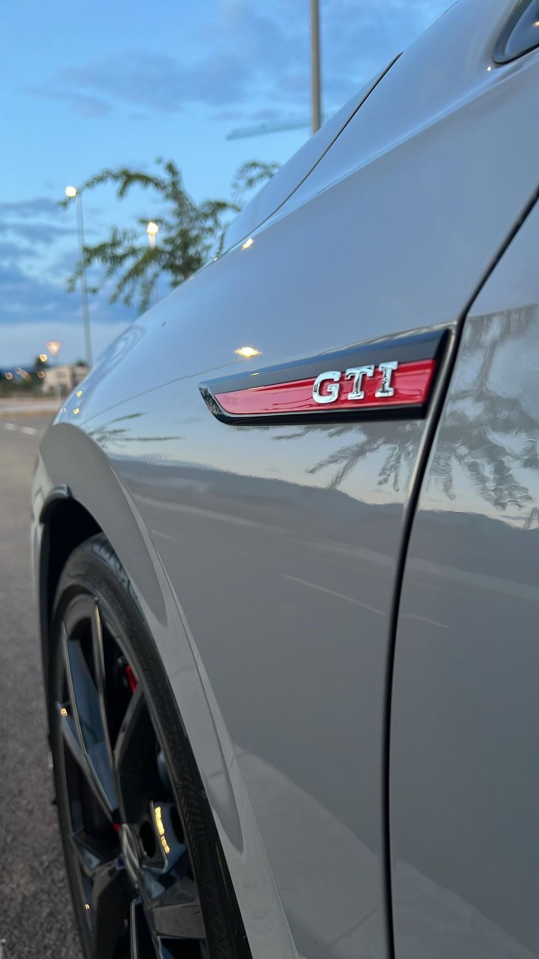 Primer plano de un automóvil Volkswagen GTI gris con un emblema 