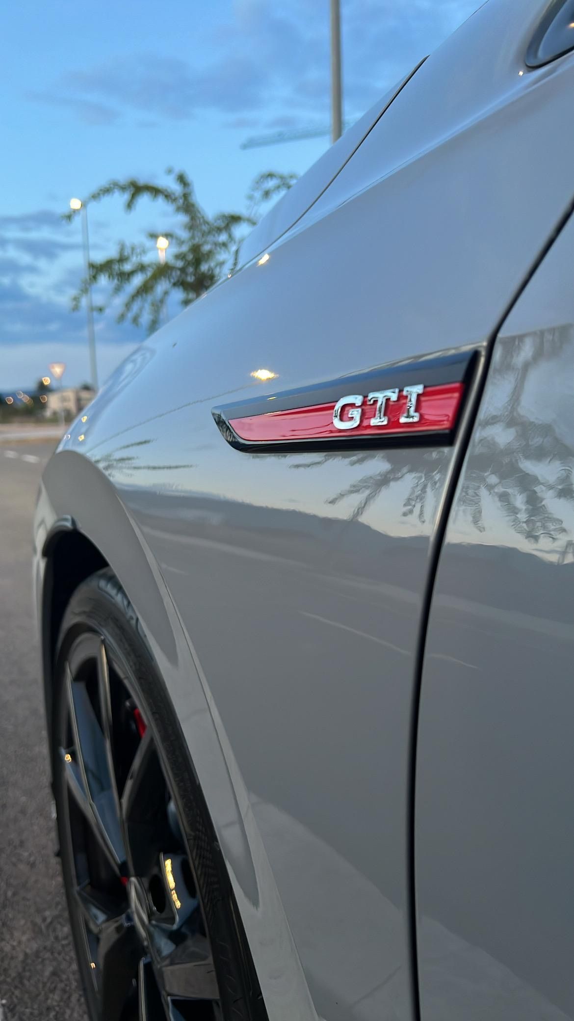 Primer plano de un automóvil Volkswagen GTI gris con un emblema