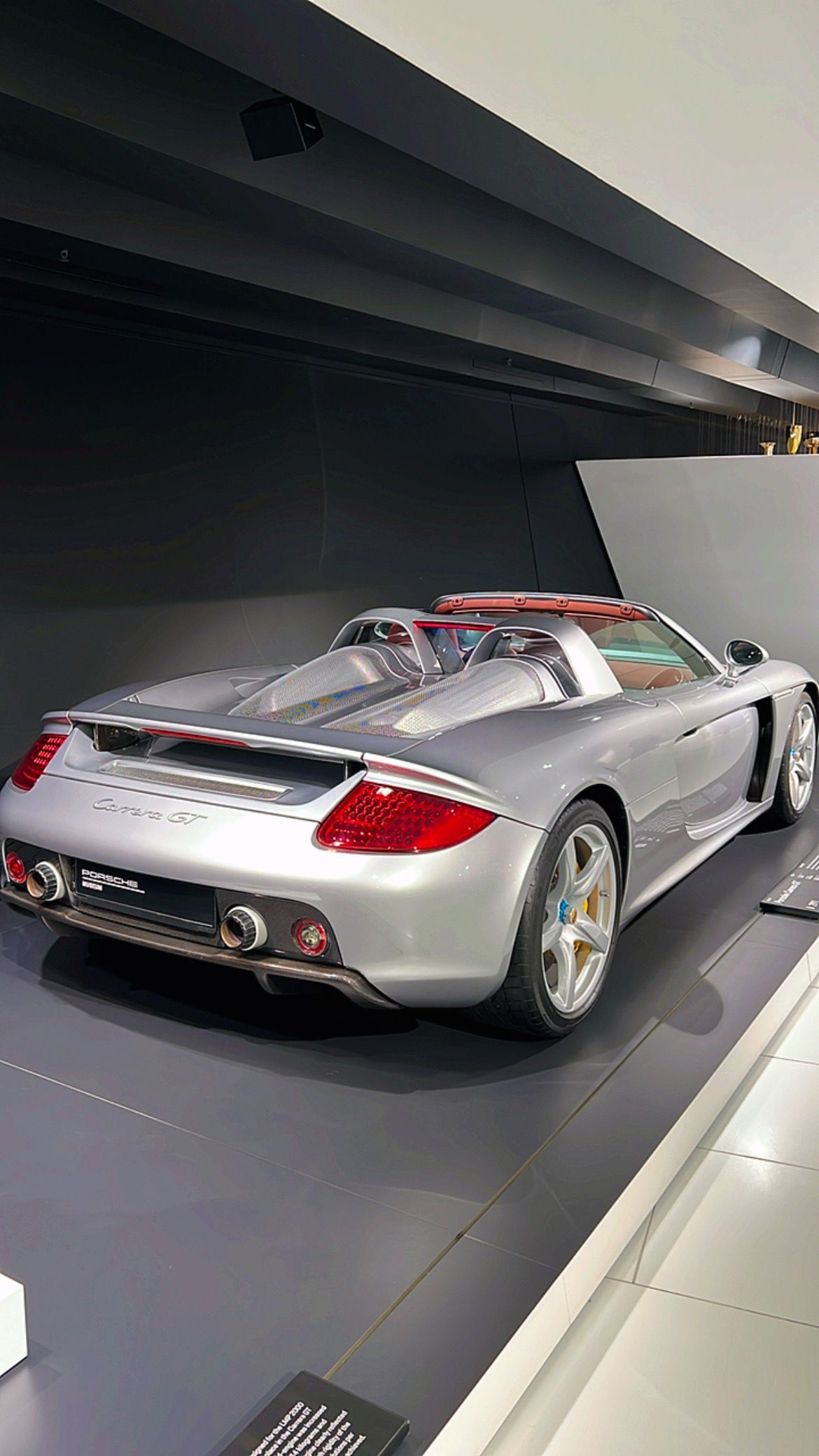 Coche deportivo Porsche Carrera GT plateado en exposición.