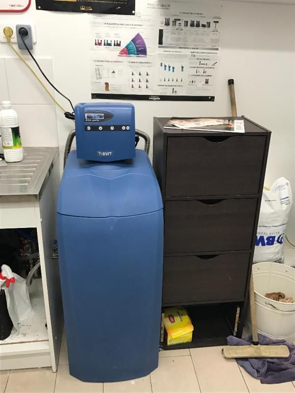 Un adoucisseur d'eau installé à côté d'une commode noire