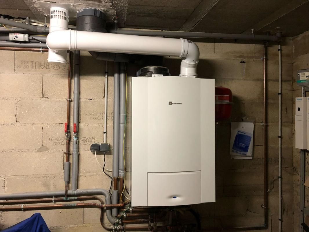 Une chaudière installée contre un mur dans une pièce sombre