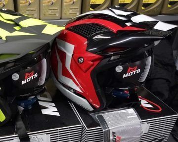 Dos cascos de motocicleta están encima de una pila de cajas.