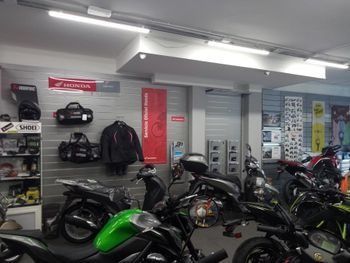 Una fila de motocicletas están estacionadas en una sala de exposición.