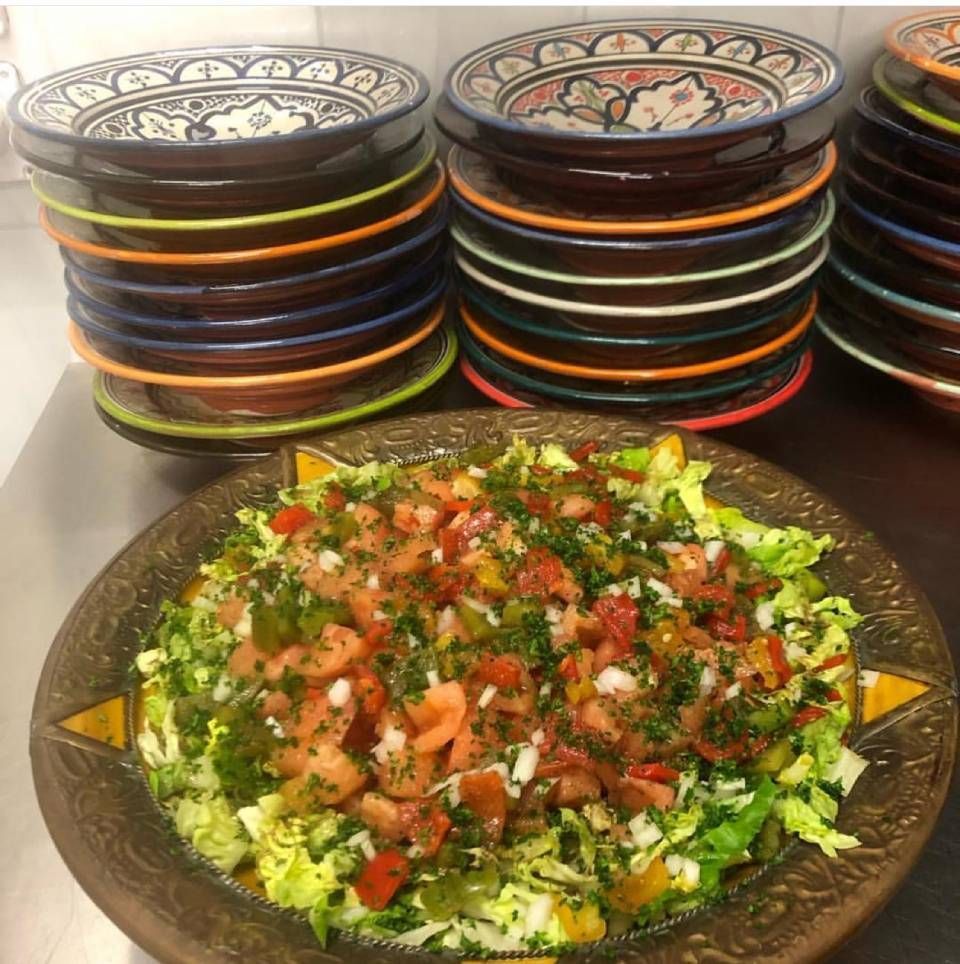 Un bol de salade se trouve devant une pile d'assiettes