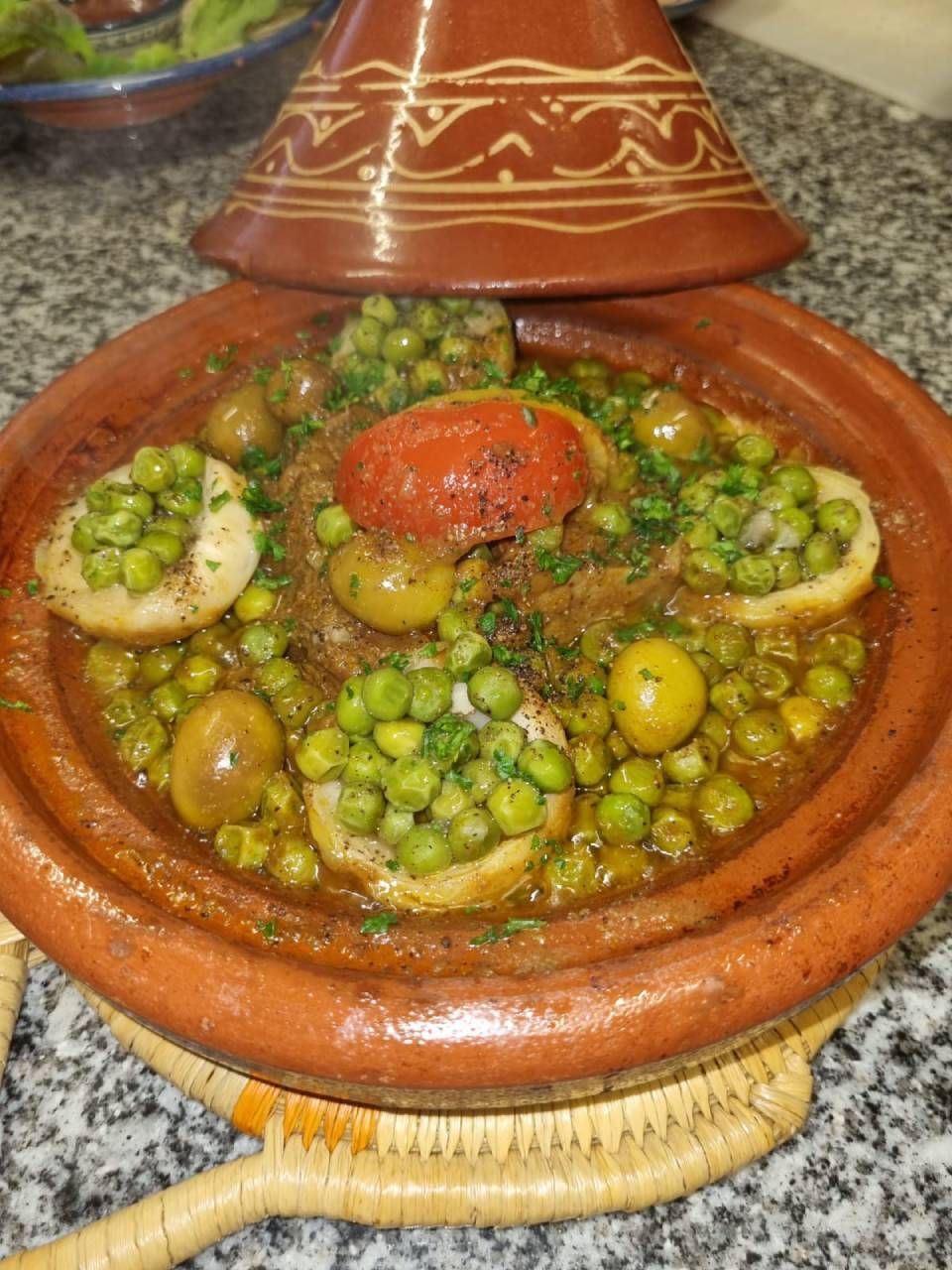Un pot de nourriture avec des pois et des olives sur une table