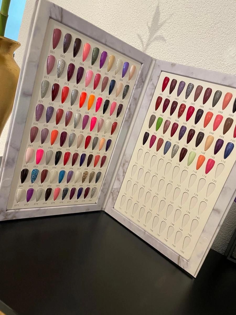 Un livre rempli de nombreux clous de couleurs différentes est posé sur une table.