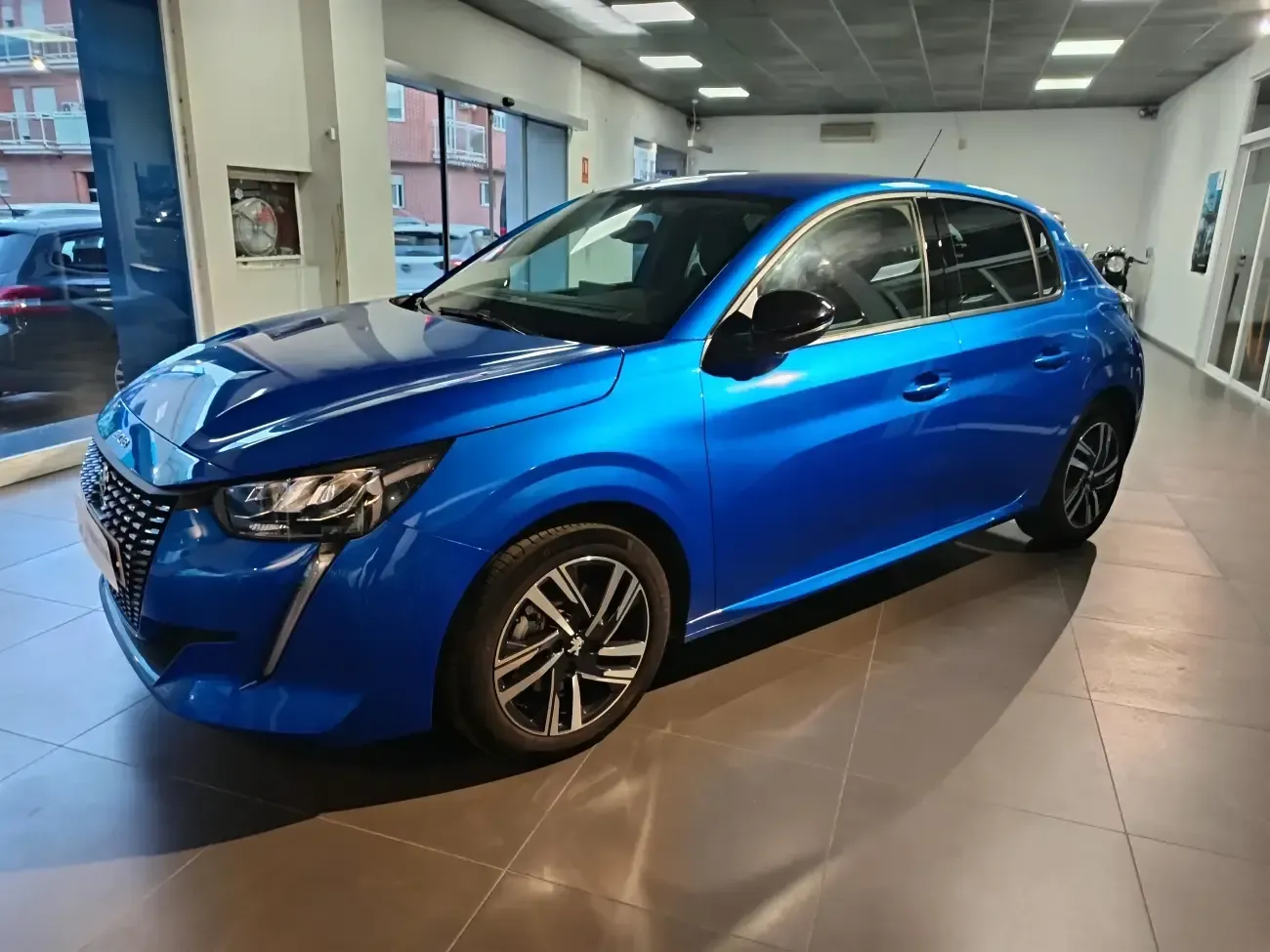 Un coche azul está aparcado en una sala de exposición.