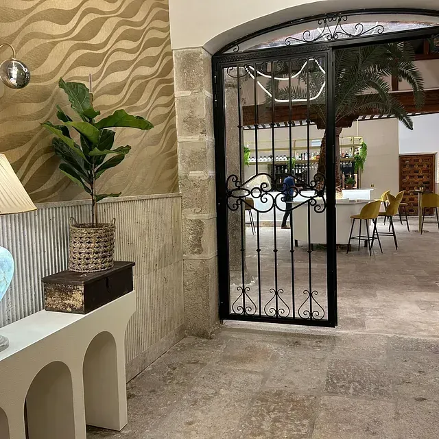 Una habitación con una puerta y una lámpara sobre una mesa.