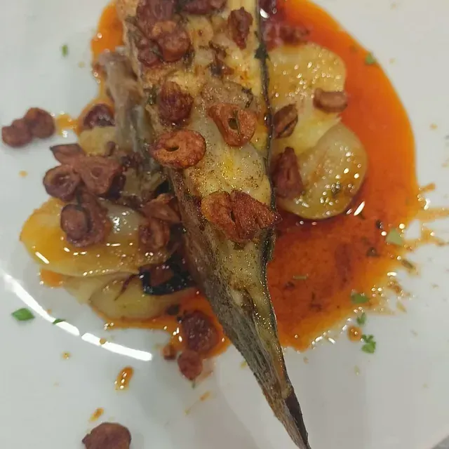 Un primer plano de un plato de comida con salsa encima.