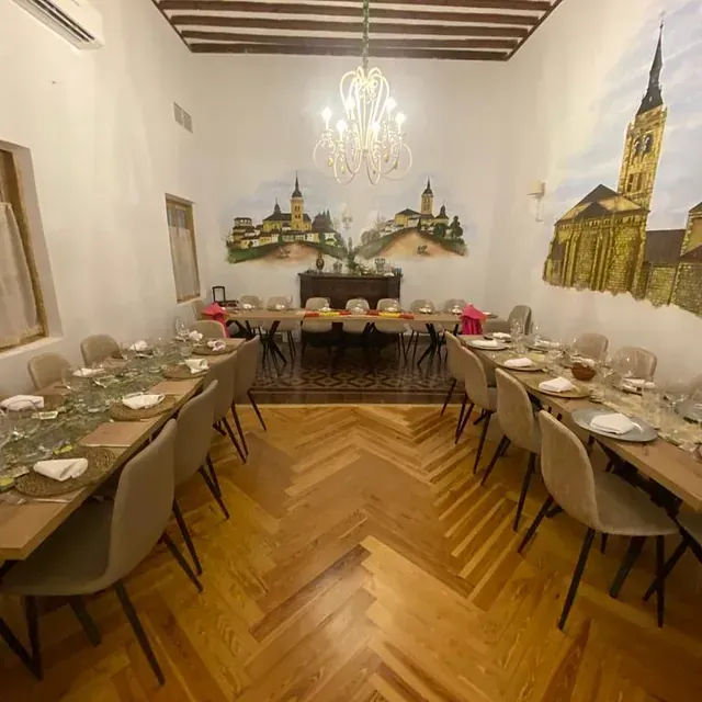 Una sala grande con mesas y sillas y un cuadro en la pared.