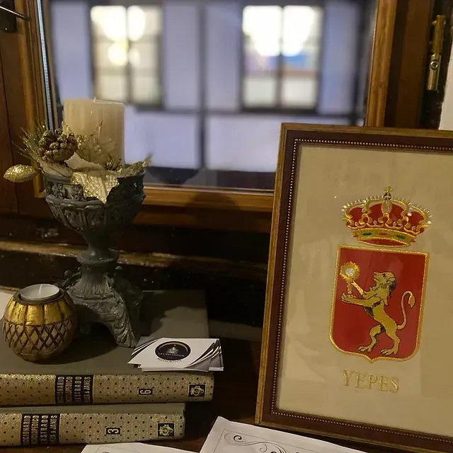 Una imagen de un león con una corona está sobre una mesa al lado de una pila de libros.