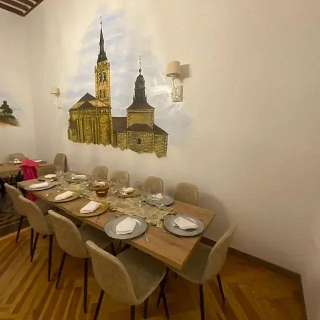 Un comedor con una pintura de una iglesia en la pared.
