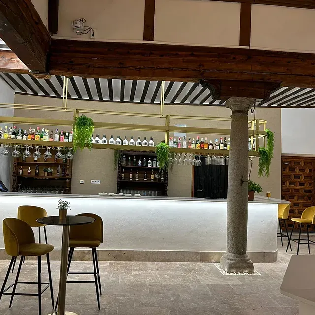 Un restaurante con barra, mesas y sillas.