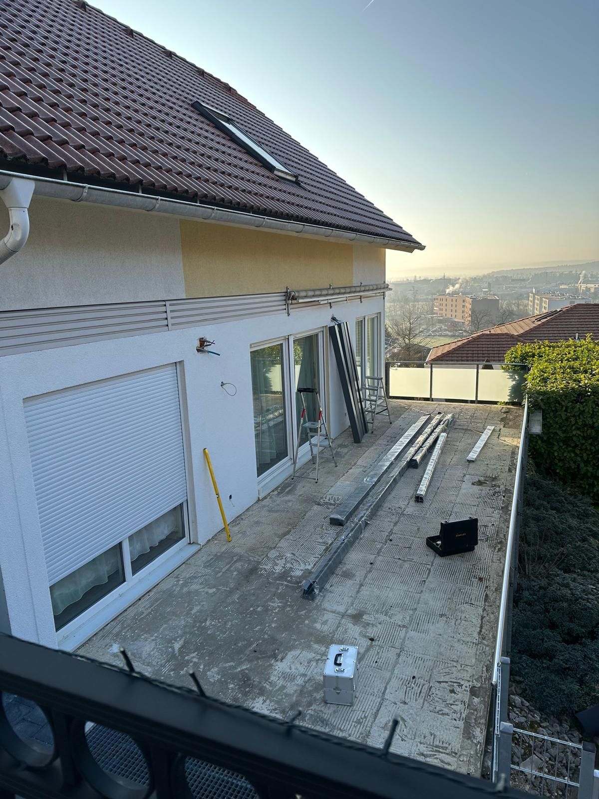 Hausaußenseite mit Terrasse. Betonterrasse mit Werkzeugen und Materialien;