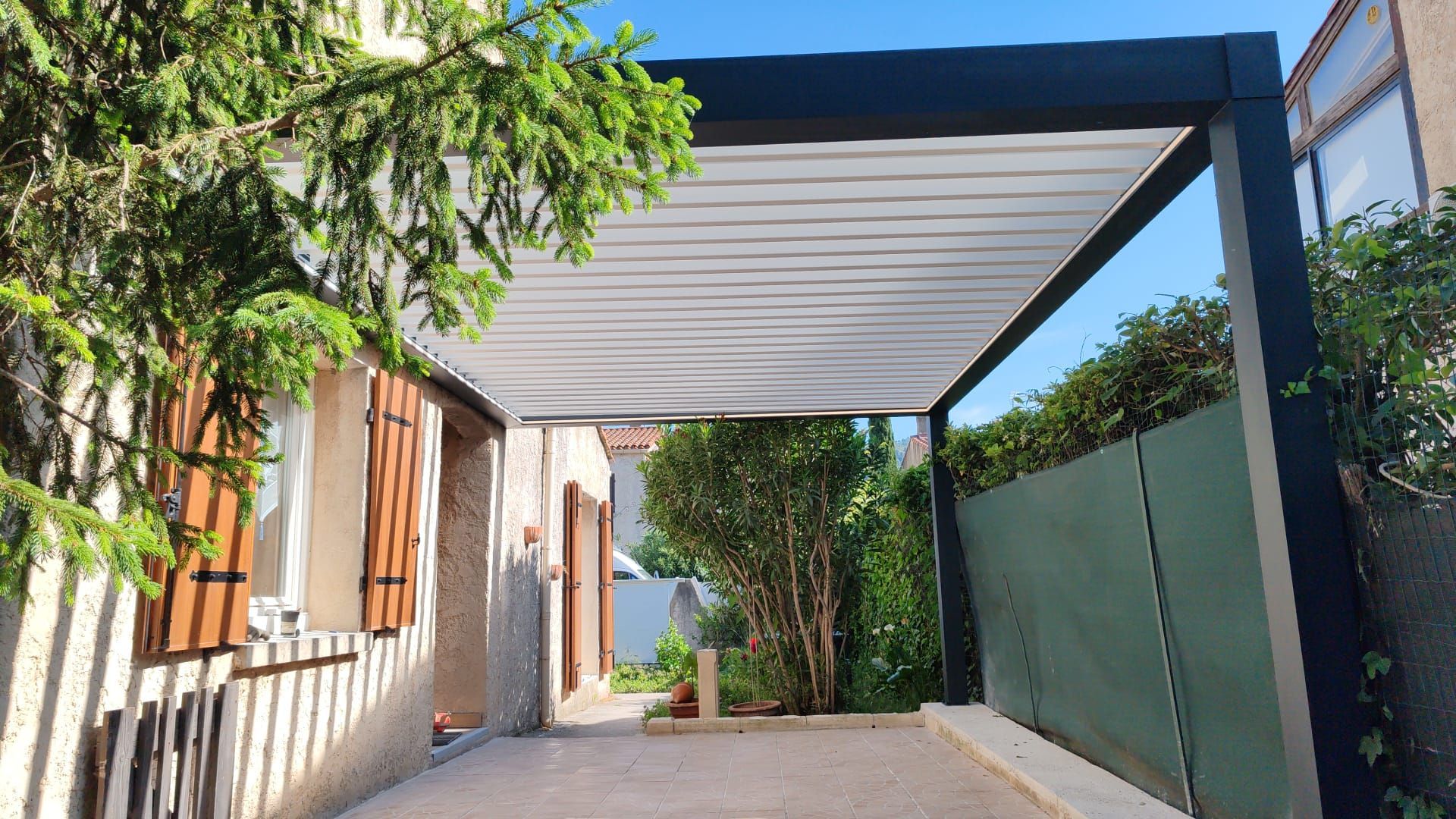 Pergola moderne avec végétation latérale et terrasse
