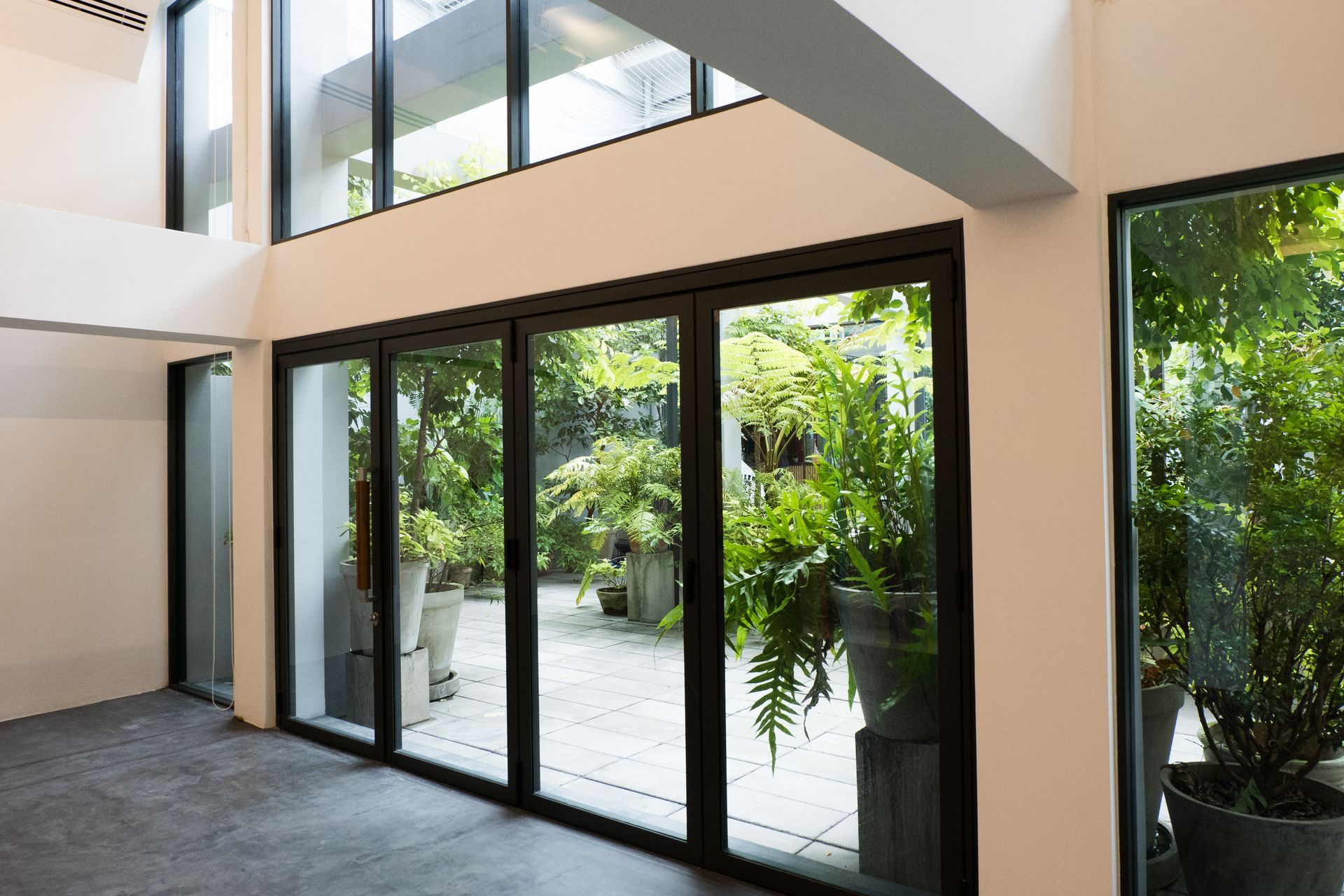 Grande pièce vide avec de grandes baies vitrées en aluminium noir