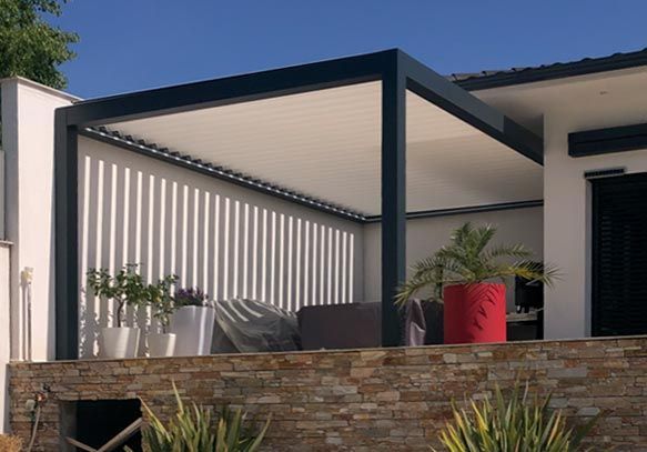 Pergola de structure métallique avec un toit, pour une terrasse avec des plantes vertes